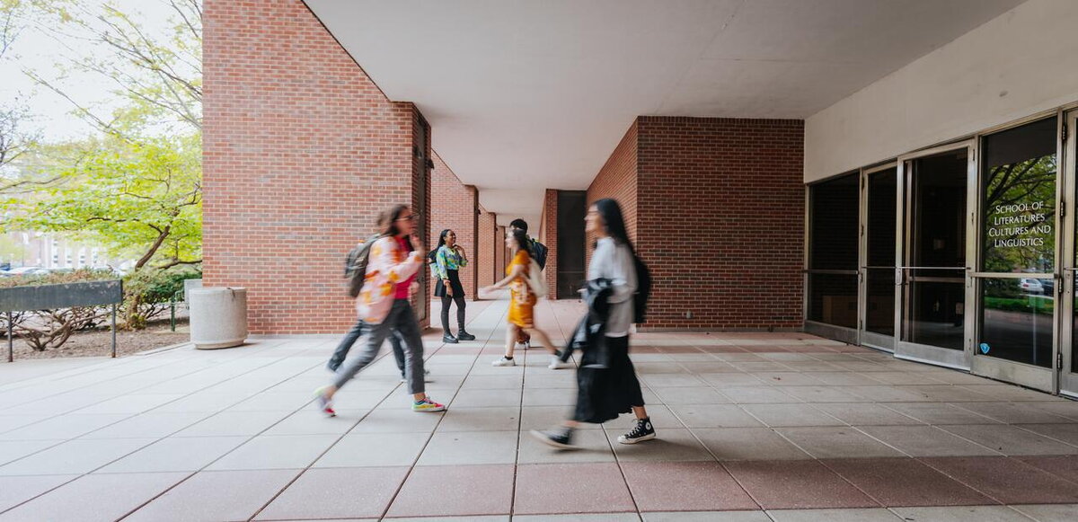students walking into languages, cultures, and linguistics building
